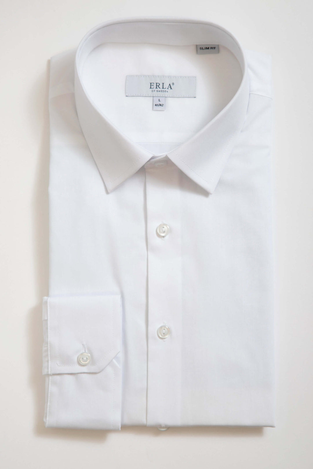Vit slim fit-skjorta med elegant design och slät yta, perfekt för formella tillfällen.
