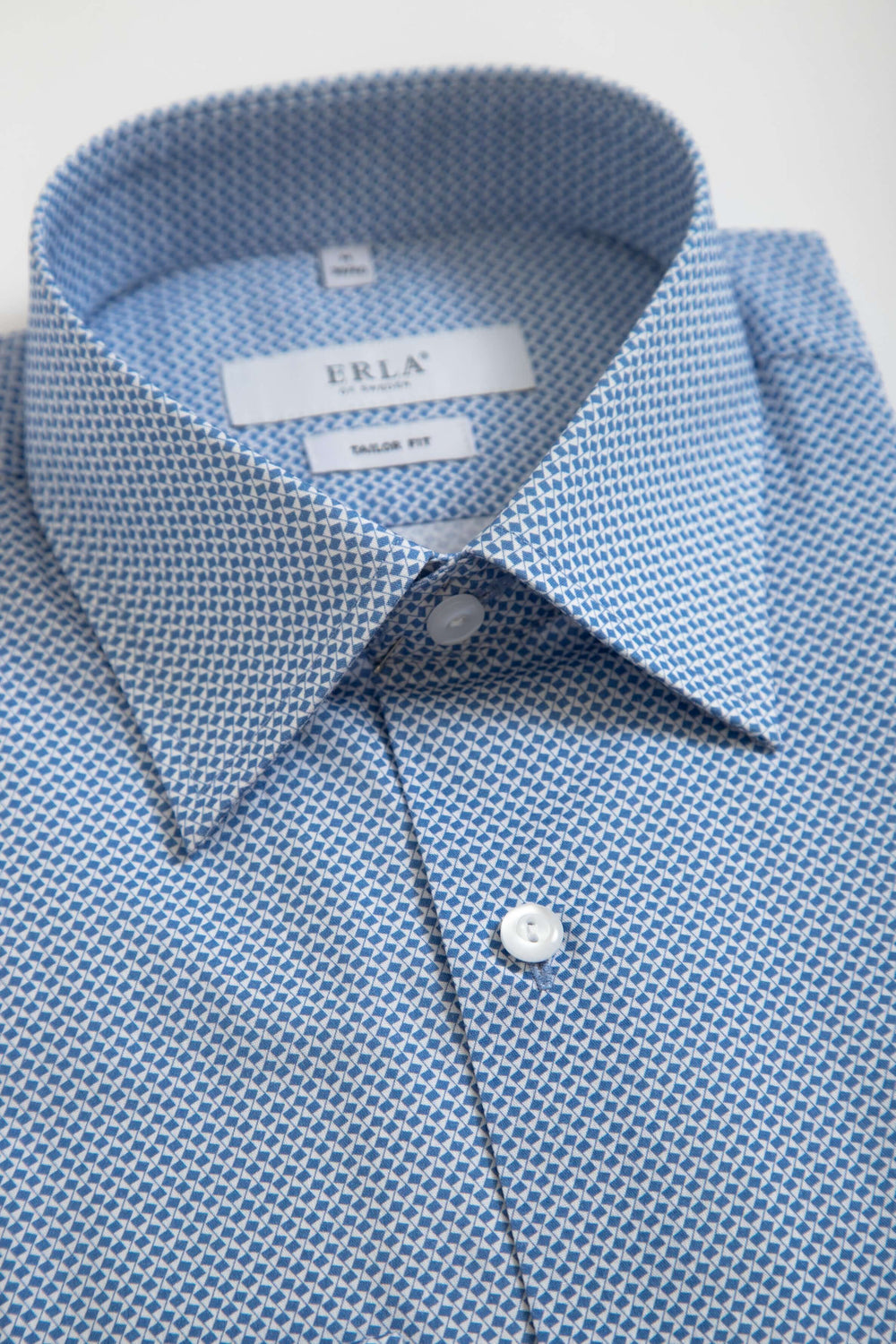 Blå skjorta med småmönster med knapp och krage som ger en stilren look.