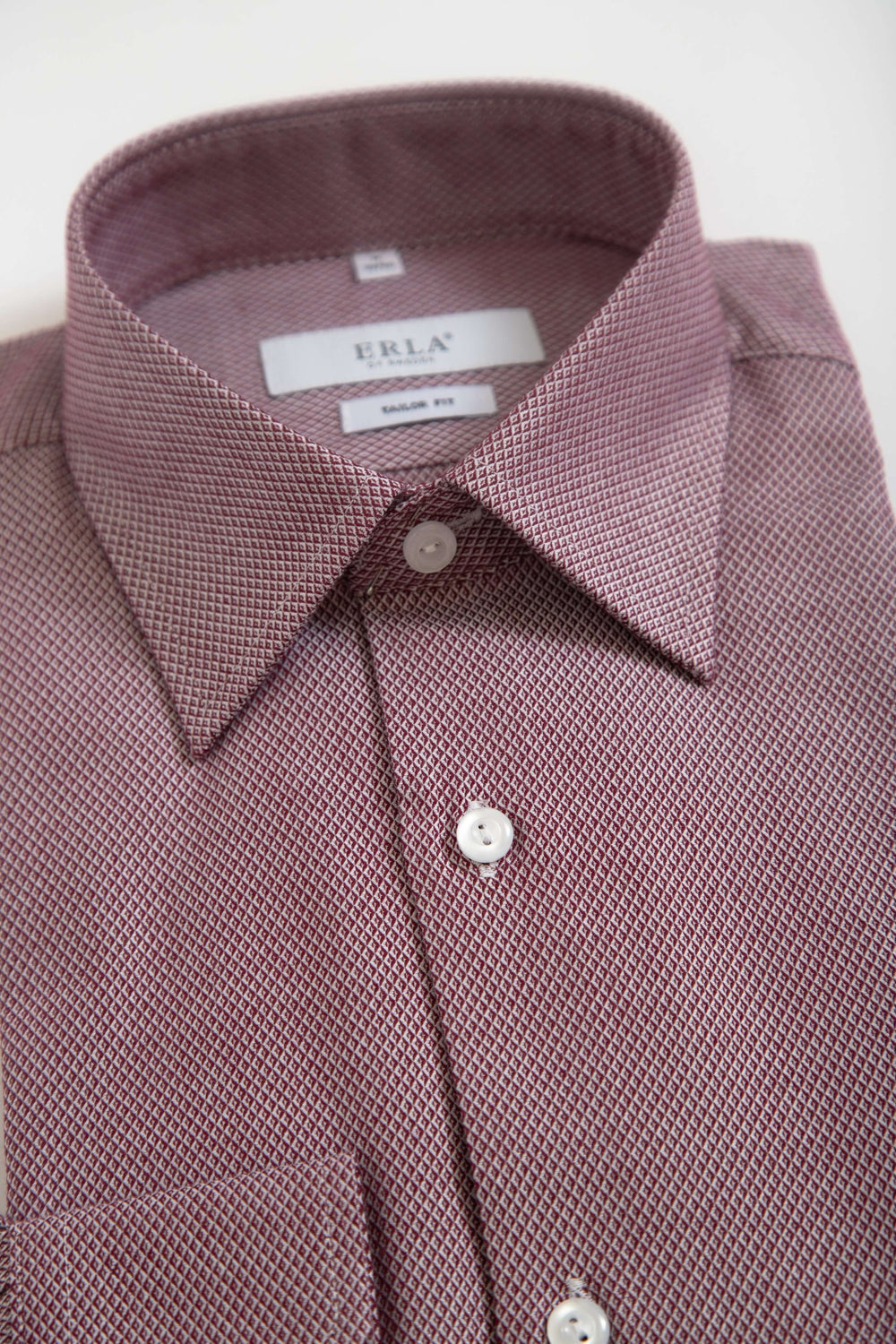 Röd skjorta med småmönster, detaljerad vy av krage och knappar, elegant och mångsidig design.