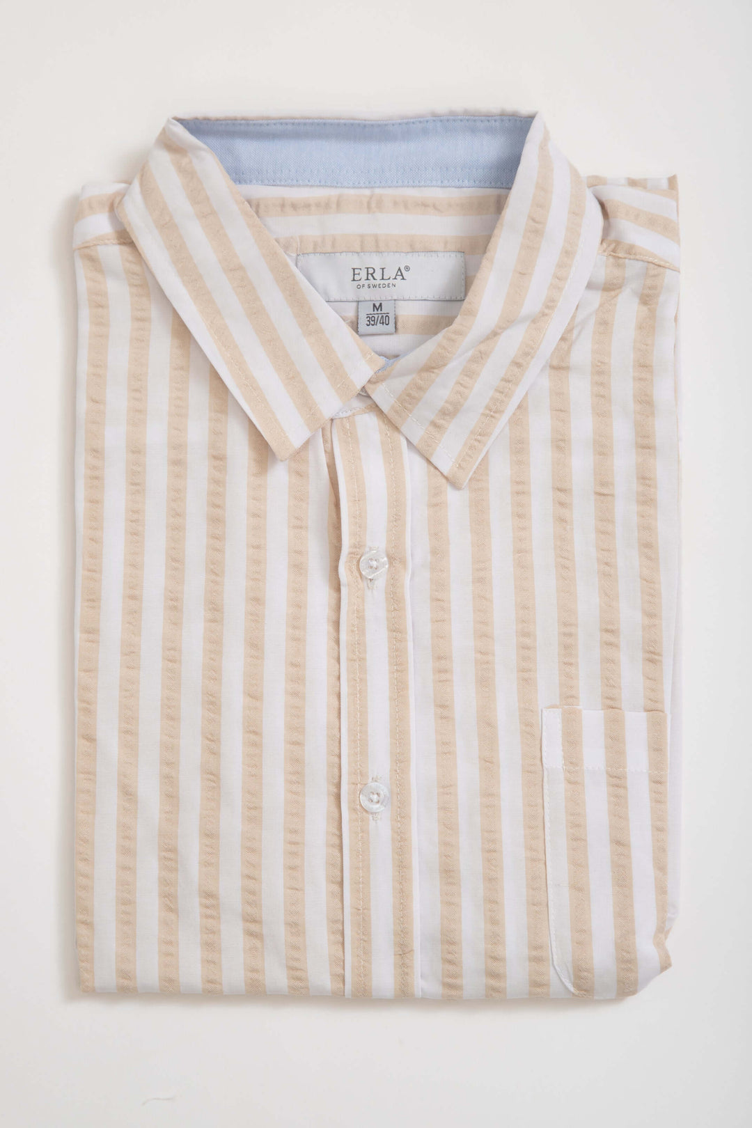 Beigerandig kortärmad seersucker-skjorta, vikta förvaringsbild med klassiska beige ränder.