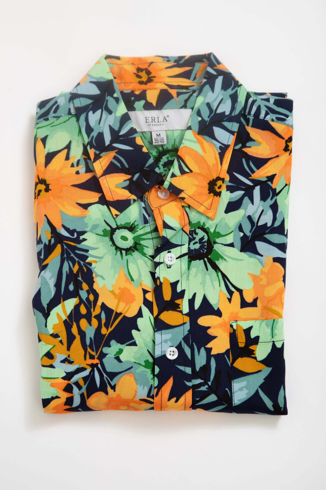 Kortärmad viskosskjorta med blommönster i orange och gröna blommor på mörk bakgrund, perfekt för sommardagar.