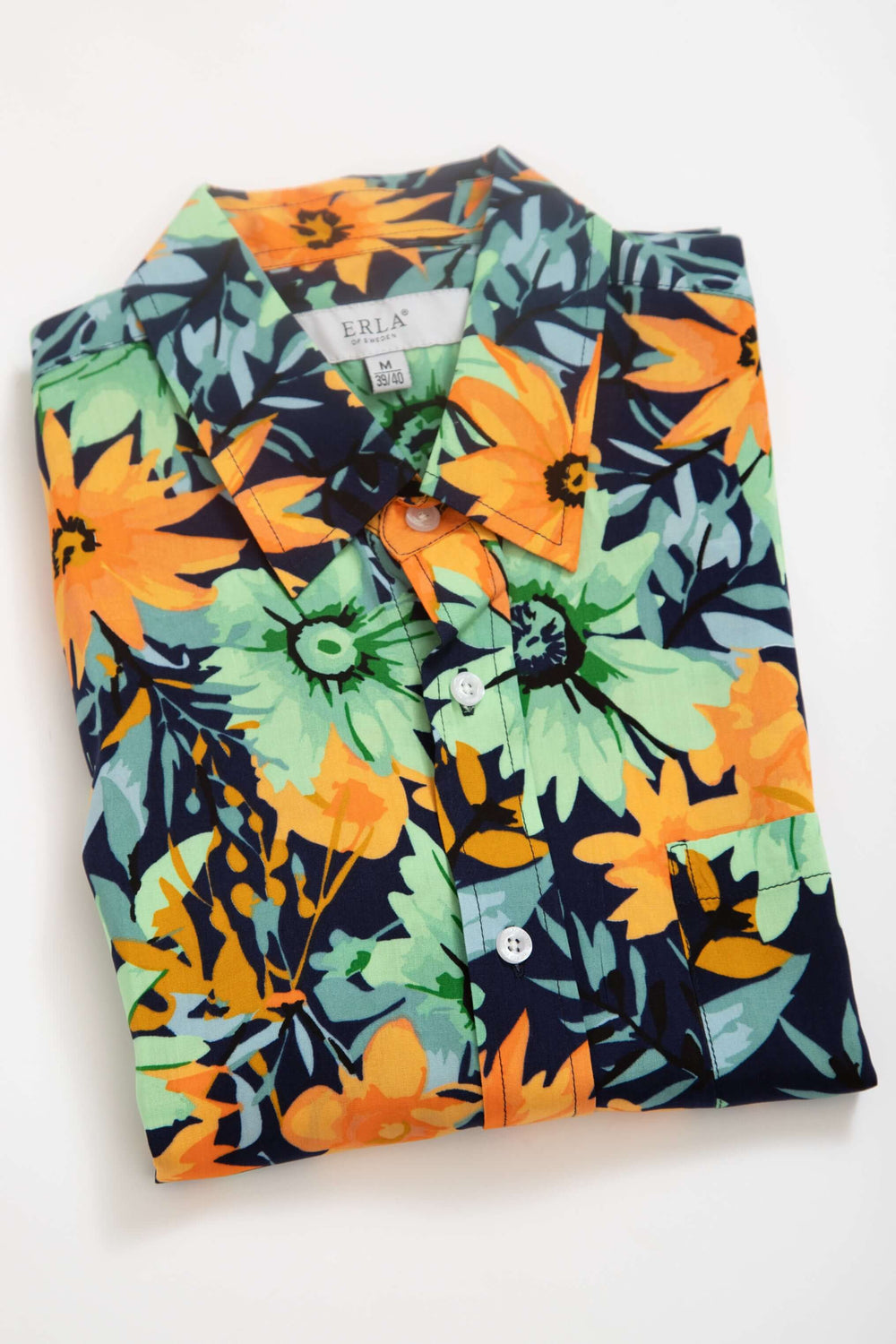Kortärmad viskosskjorta med blommönster i färgstarkt mönster av blommor och gröna blad.