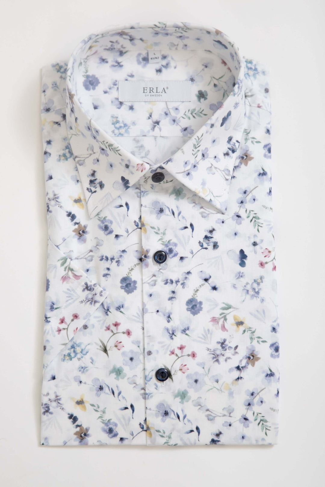 Vit Kortärmad Skjorta med blommigt mönster, fräsch vit bas och stilrent blommigt mönster i mjuka färgtoner.