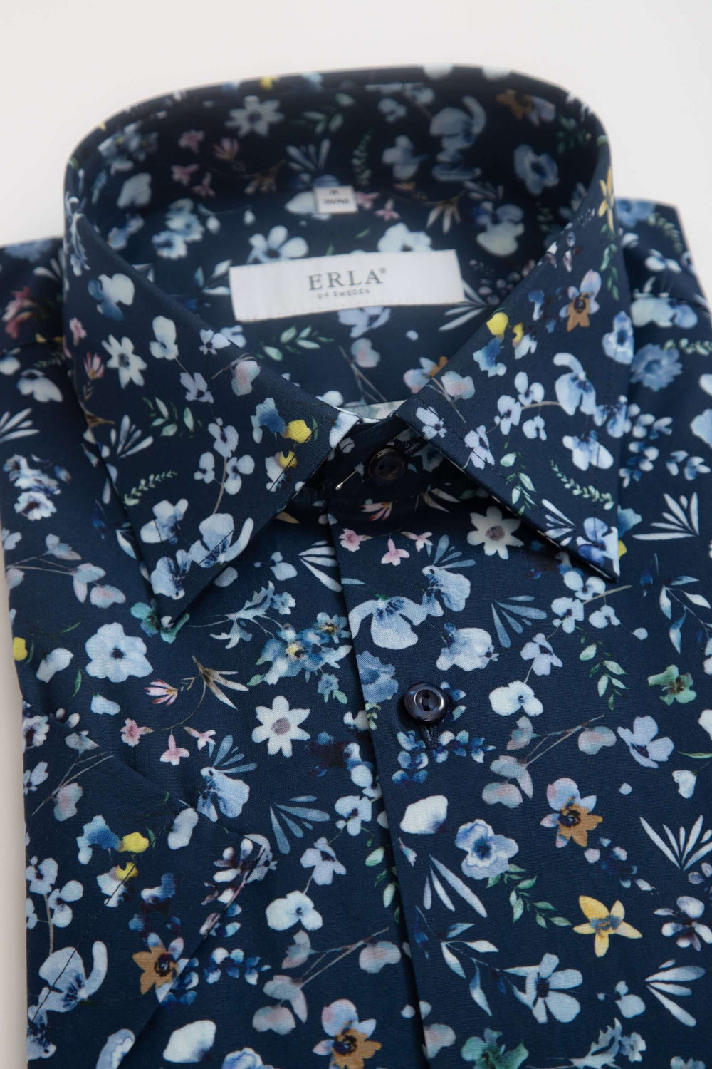 Mörkblå kortärmad skjorta med blommigt mönster, elegant blommigt design i dämpade nyanser.