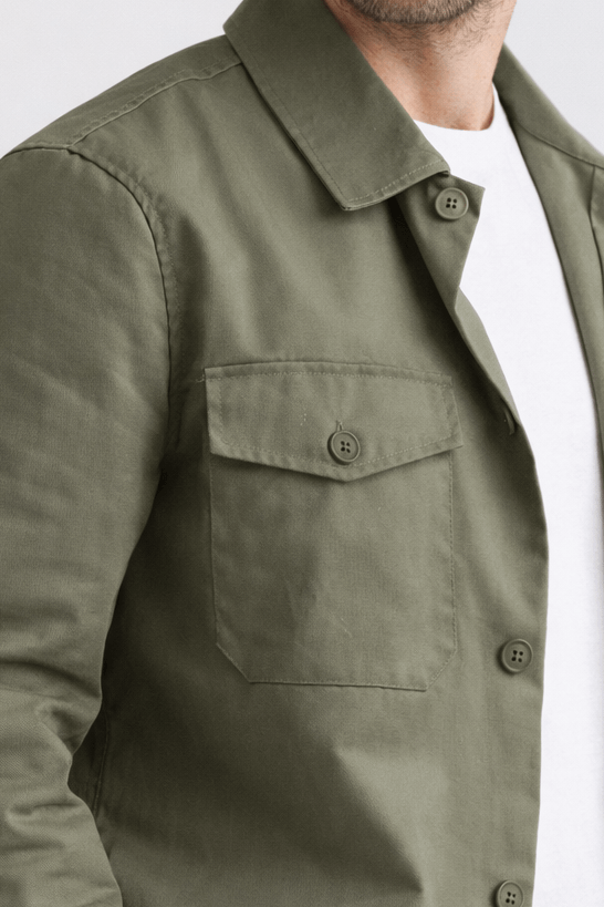 Olivgrön City Overshirt bärs av man, designad med bröstfickor för en modern och avslappnad look.