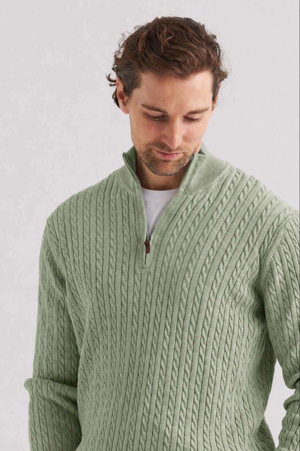 Grön kabelstickad tröja half zip i mjuk grön nyans med halv dragkedja och kabelstickning.