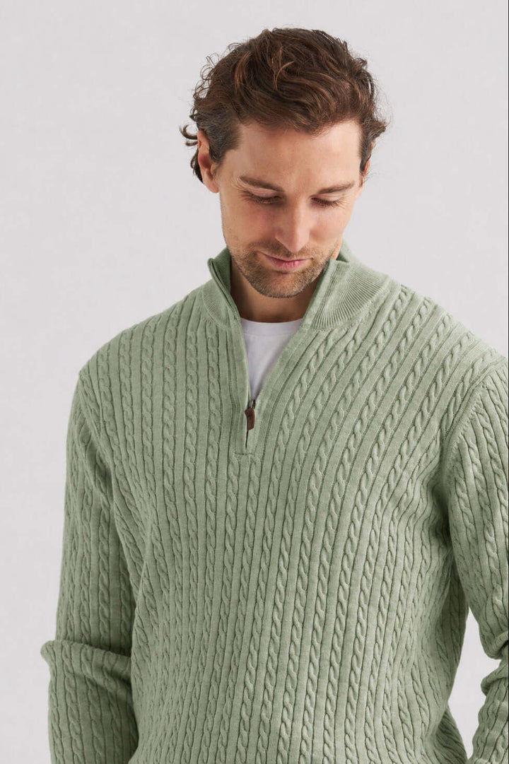 Grön kabelstickad tröja half zip i mjuk grön nyans med halv dragkedja och kabelstickning.