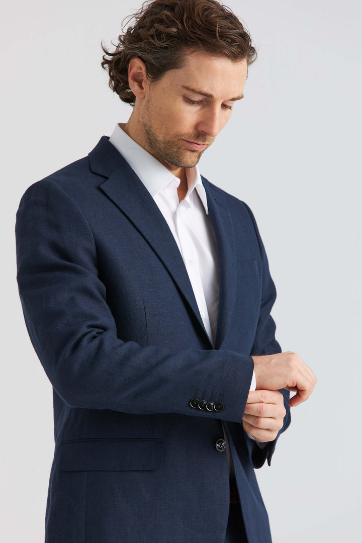Linnekavaj Marinblå på man som justerar ärmen, elegant stil för vår och sommar.