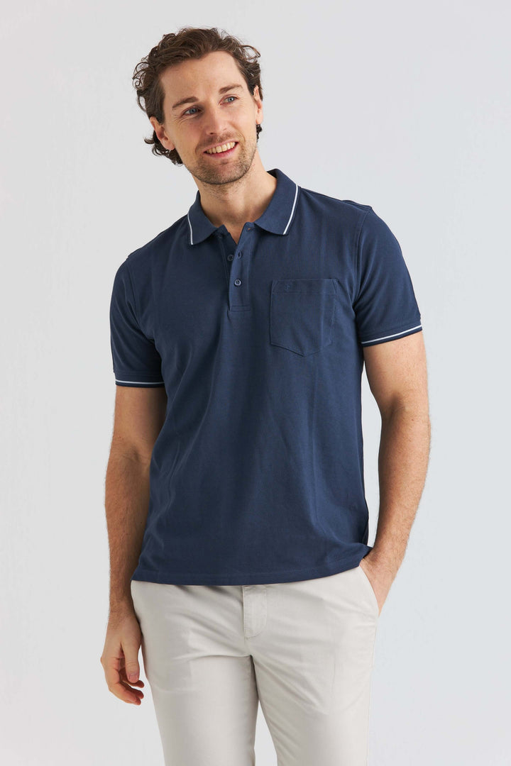 Marinblå Pikétröja med Kontrastdetaljer, modell bär pikétröjan med ficka och kontrastkanter.