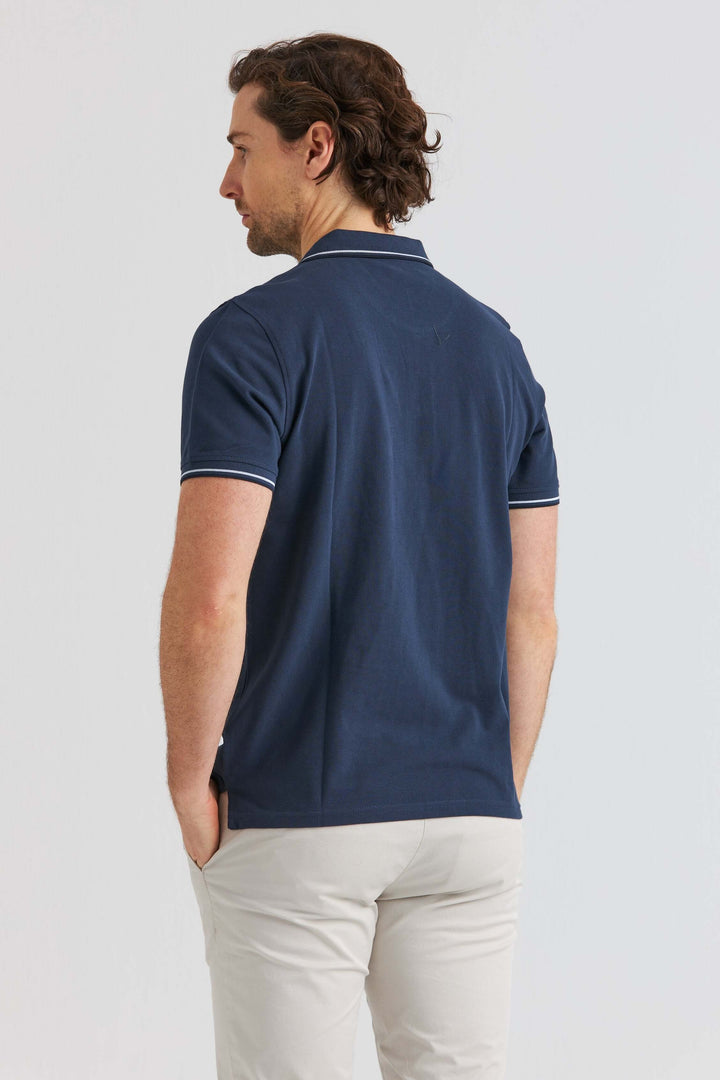 Marinblå Pikétröja med Kontrastdetaljer, back view of a man wearing a navy polo shirt.