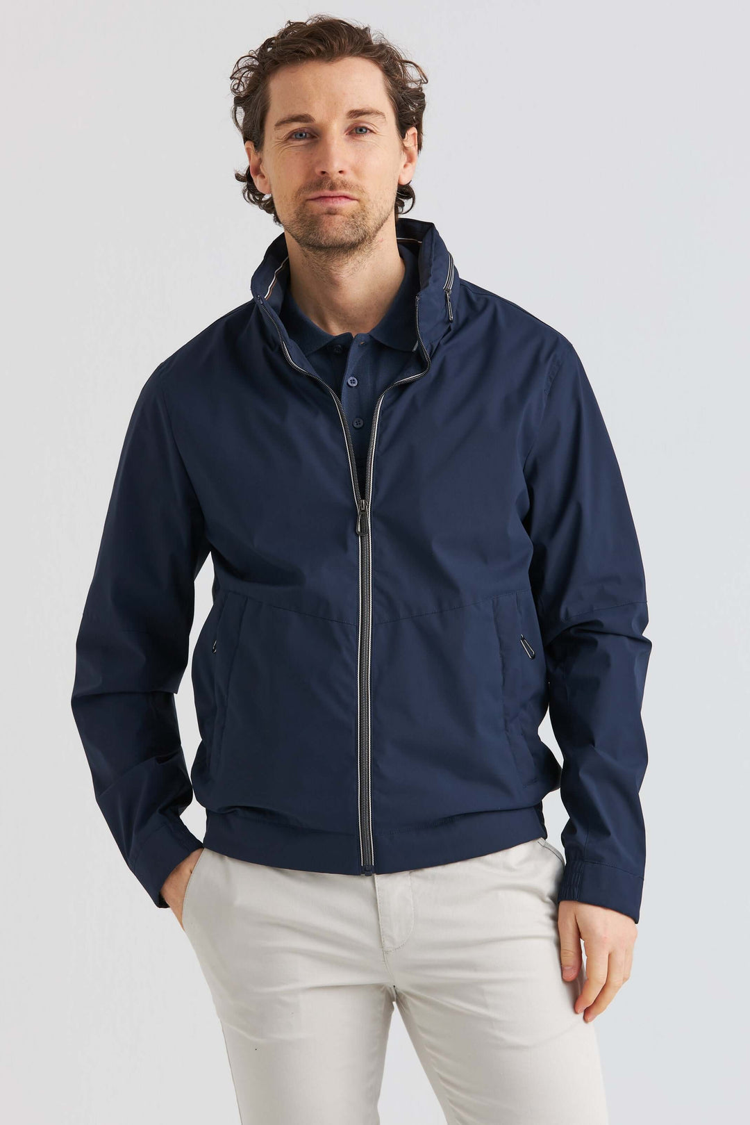 Marinblå Lightweight Vårjacka som visar en man i en stilren marinblå vårjacka med huva, perfekt för vårbruk.
