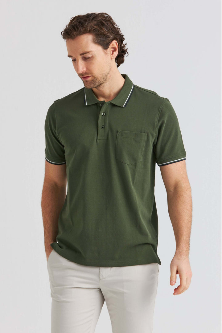 Grön Pikétröja med Kontrastdetaljer bärs av man, med en ficka och snygga detaljer i hållbar design.