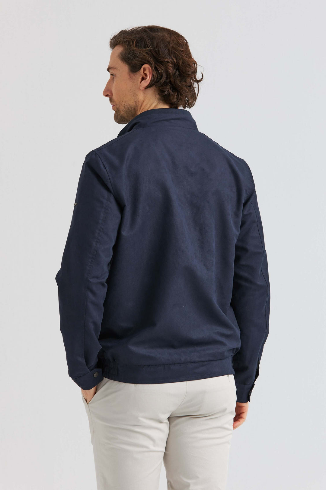 Man wearing a marinblå jacka i Soft Suede, showing the back view and modern design.