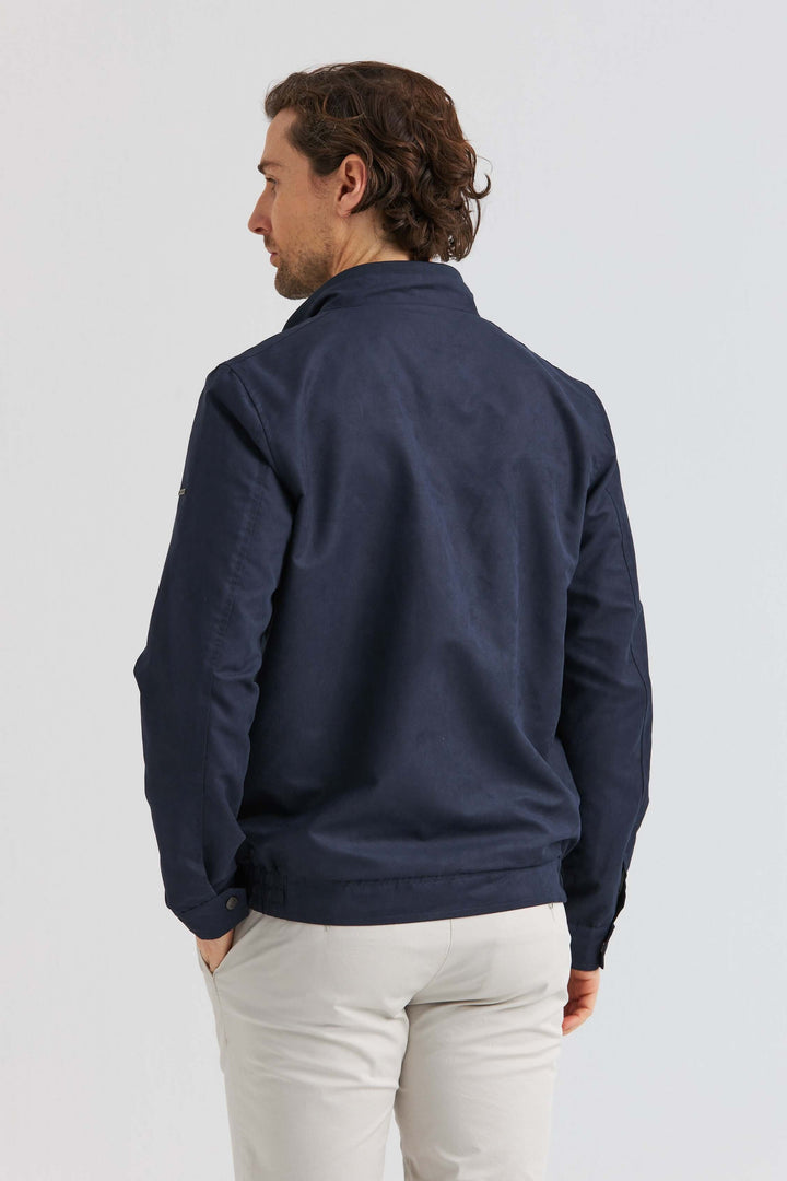 Man wearing a marinblå jacka i Soft Suede, showing the back view and modern design.