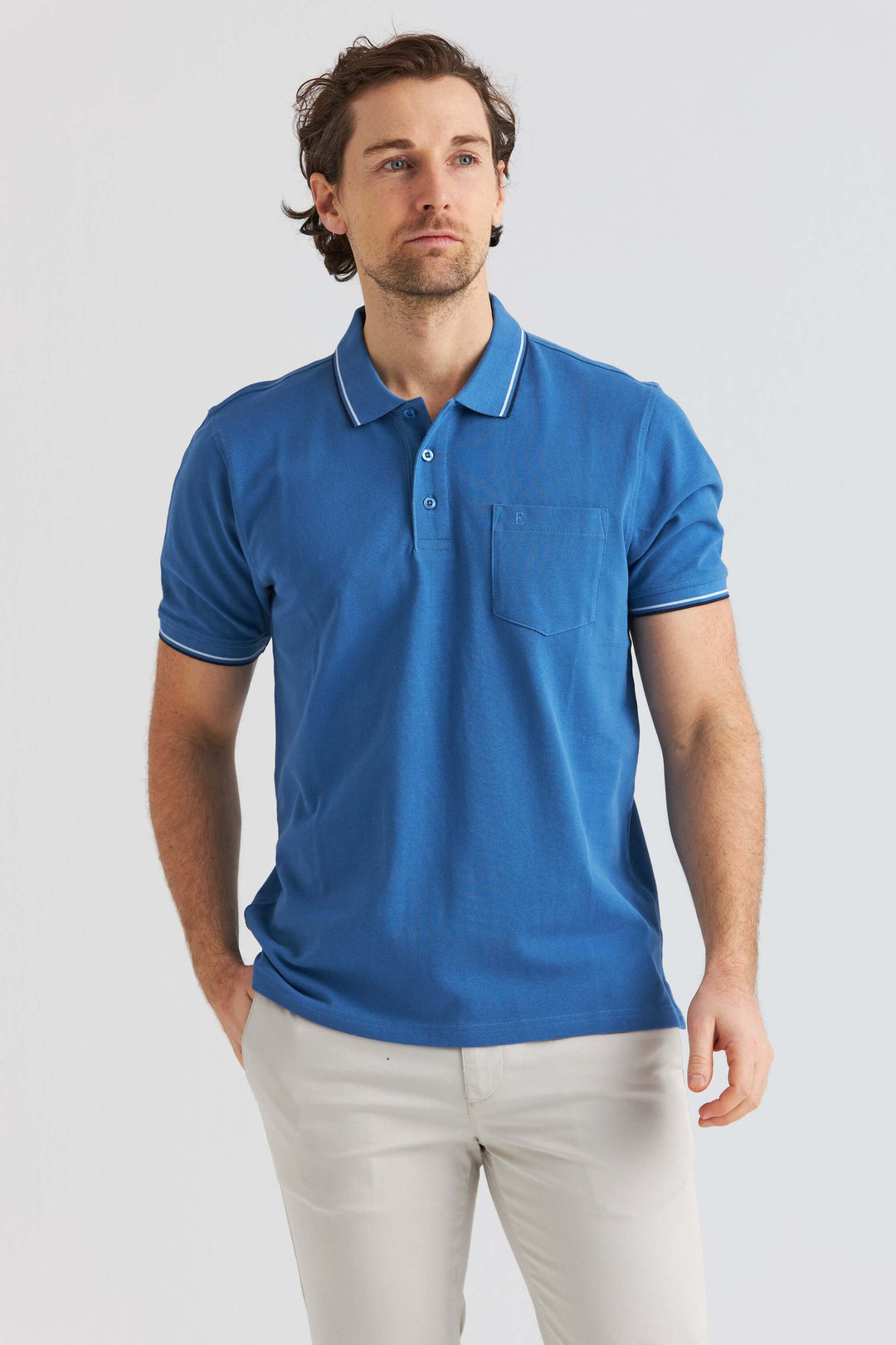 Blå Pikétröja med Kontrastdetaljer som visas av man med kortärmad stil.