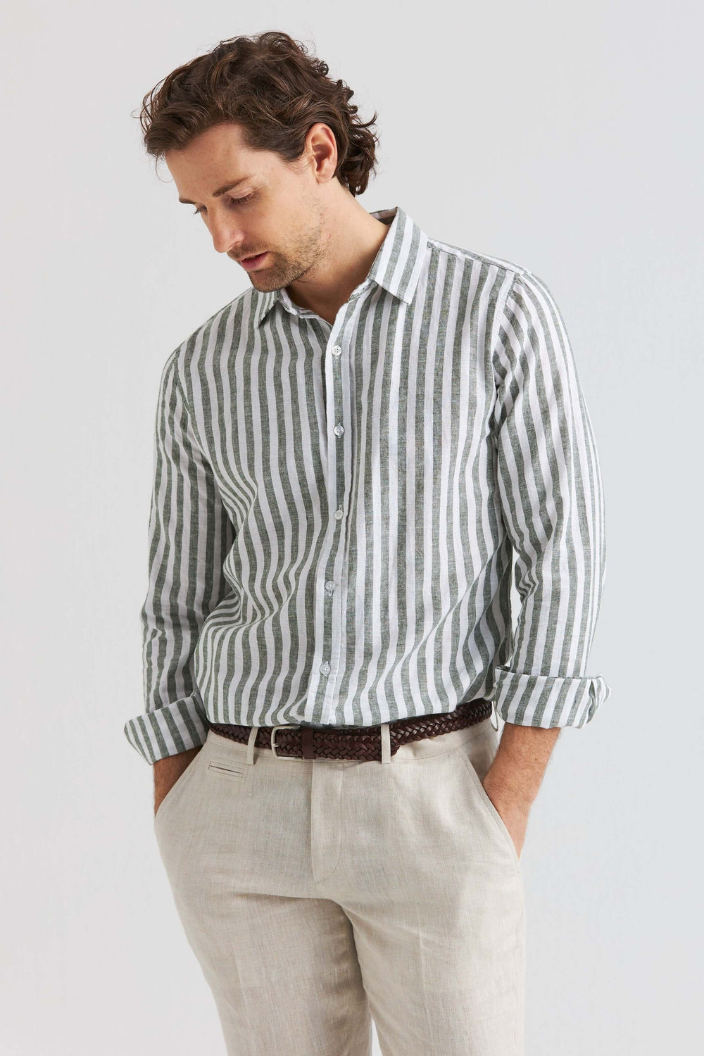 Grön randig linneskjorta på man med ljusa byxor, luftig och bekväm design för varmare dagar.