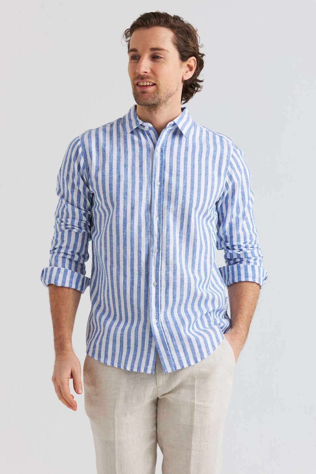 Man i blå randig linneskjorta med klassisk krage, perfekt för varmare dagar.