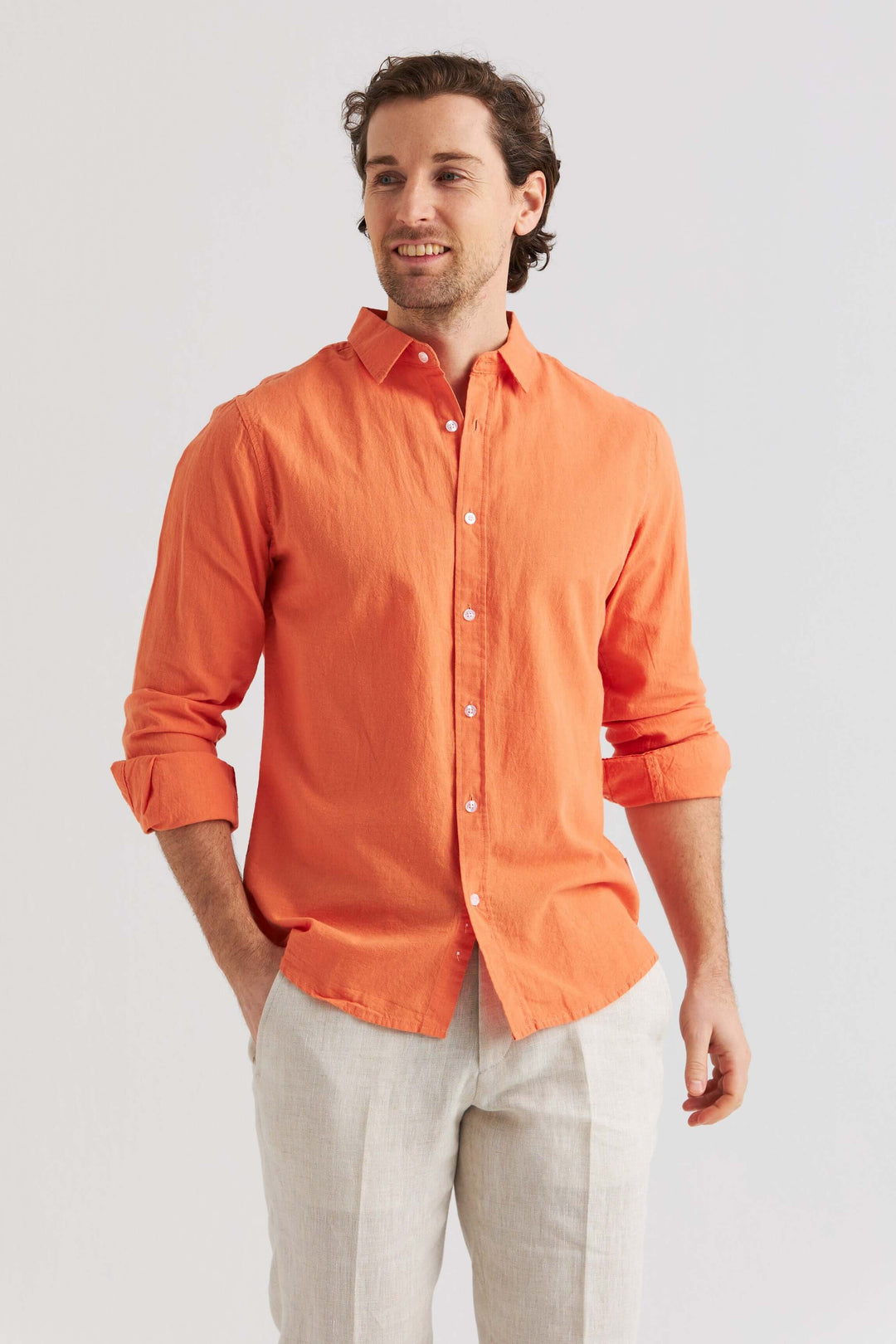 Man i linneskjorta orange med lång ärm, perfekt för vår och sommar i avslappnad stil.
