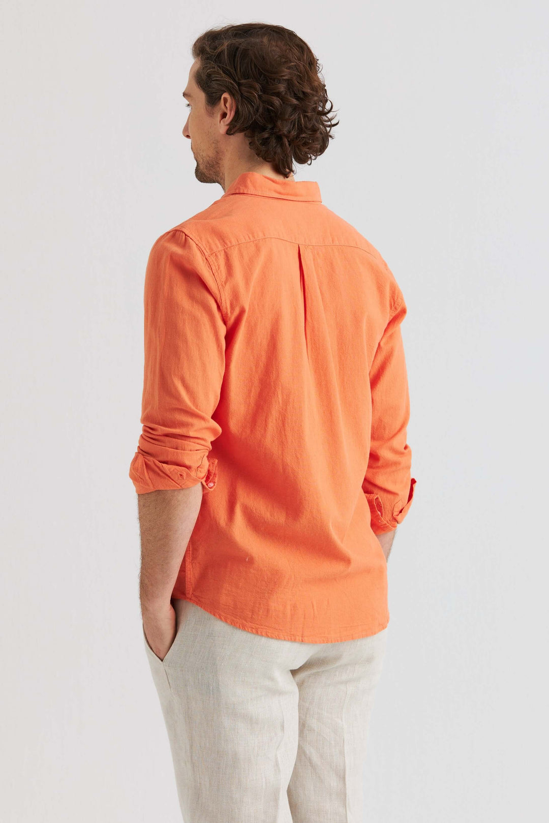 Toppvy av en man som bär Linneskjorta Orange, långärmad skjorta av linne och bomull i en livlig orange färg.