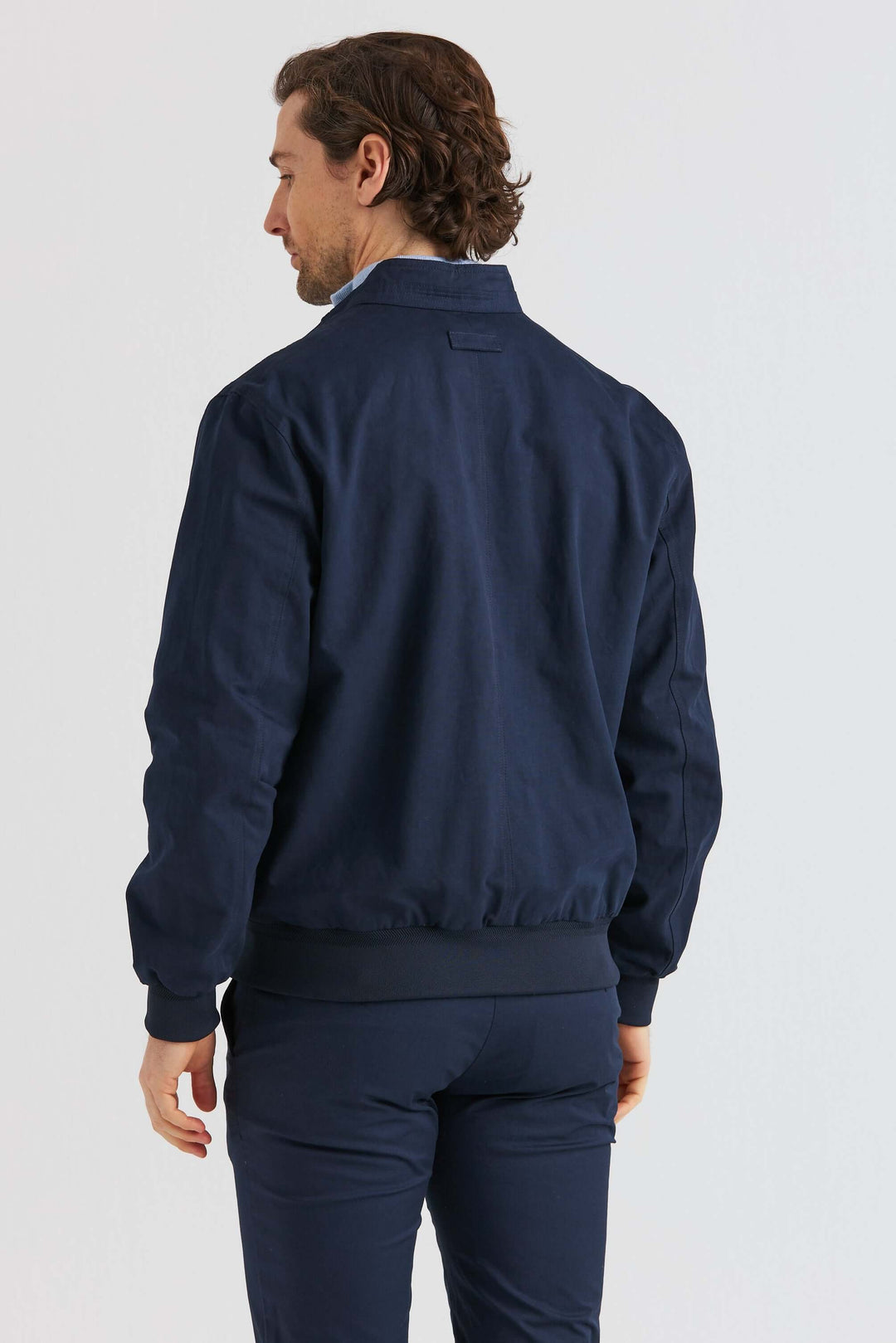 Marinblå Vårjacka i bomullsblandning sedd bakifrån, stilren design och hög komfort.