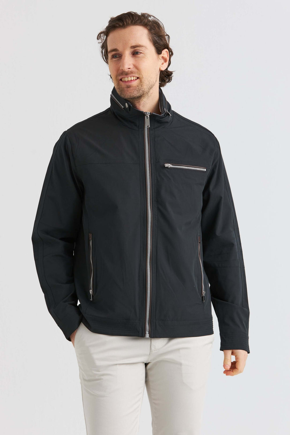 Man bär en midjekort jacka svart med detaljer som blixtlås och fickor, perfekt för stiliga outfits.