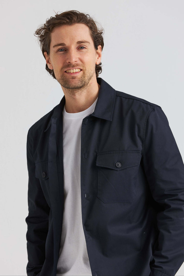 Marinblå City Overshirt visad av man, stilren design med fickor, perfekt som ytterplagg.