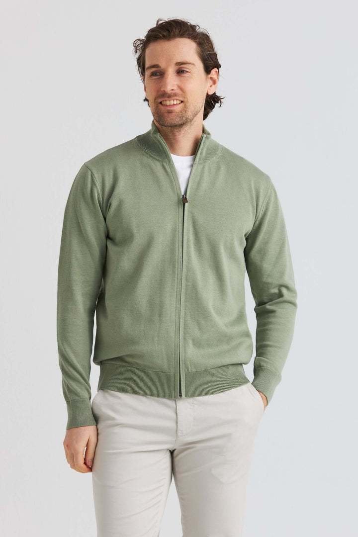 Grön bomullströja full zip bärs av modell i lätt bomull, visar stil och komfort i avslappnad miljö.