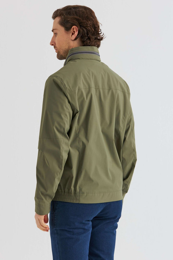 Man som bär en Grön Lightweight Vårjacka sett bakifrån, med olivgrön färg och praktiska detaljer.