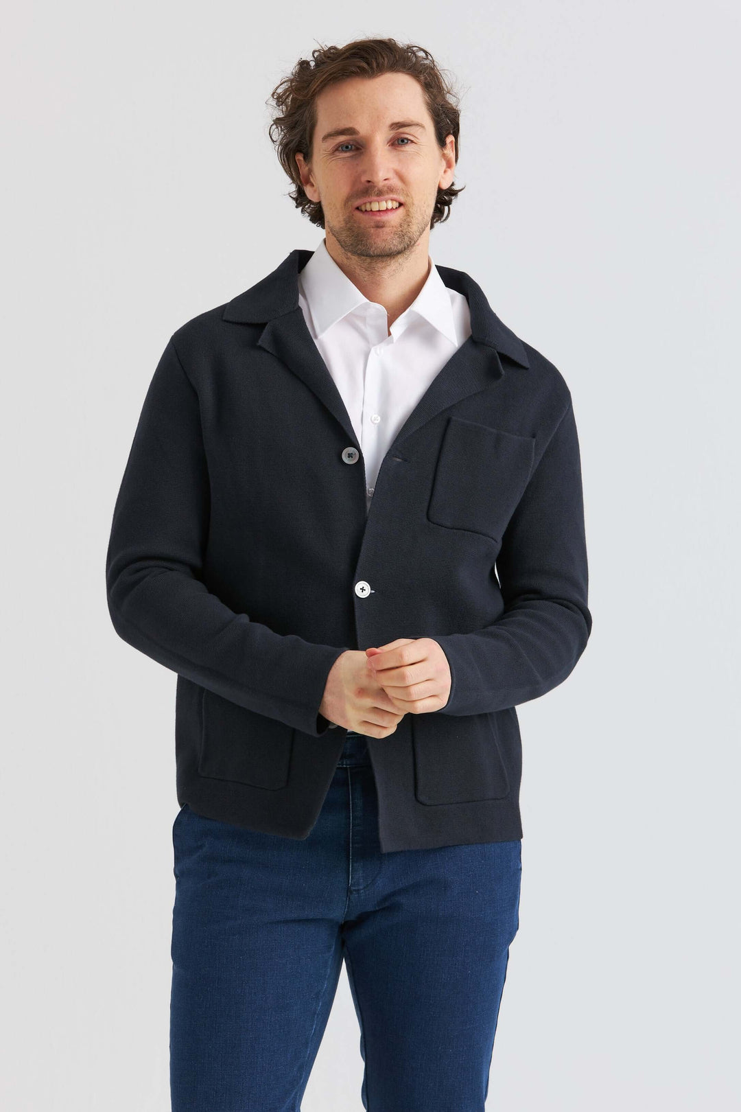 Marinblå Stickad Overshirt med knappar, bärs över vit skjorta för en smart look.