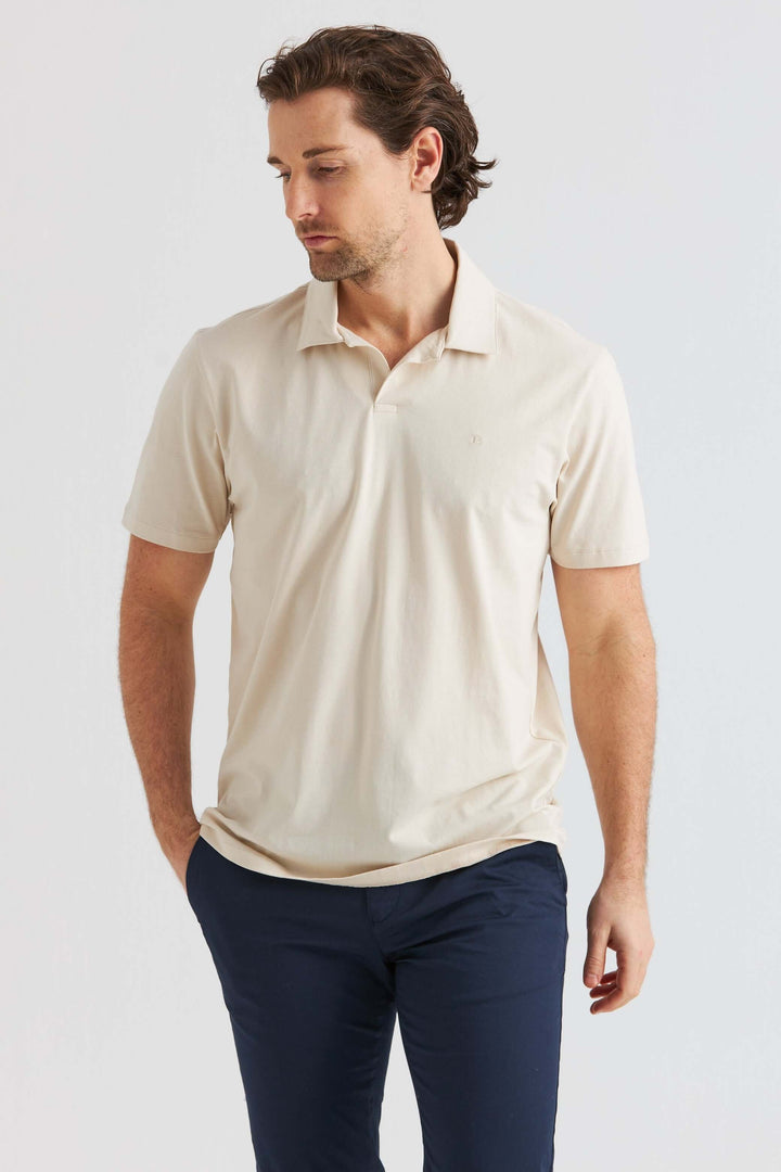 Beige Pikétröja som bärs av man med kortärmad design och avslappnad passform.