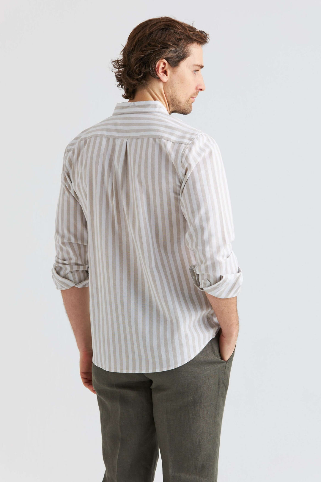 Beige randig linneskjorta med långärmad design, sedd bakifrån, perfekt för varmare väder.