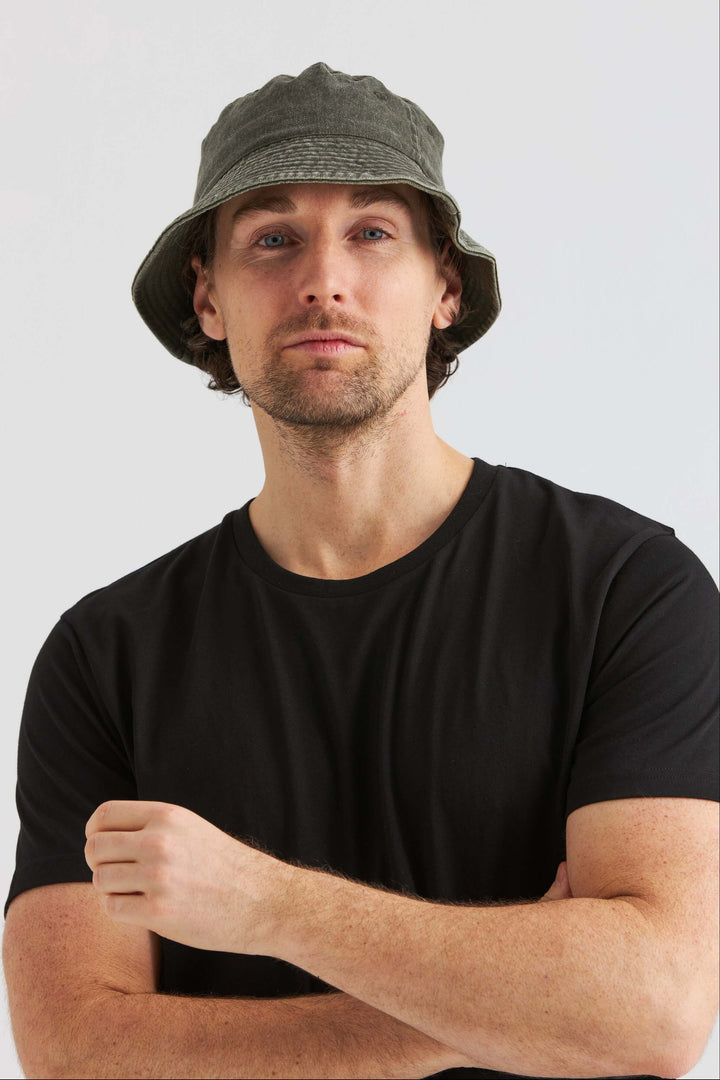 Man wearing a Grön Bucket Hat Washed Cotton with a black t-shirt, posing confidently.
