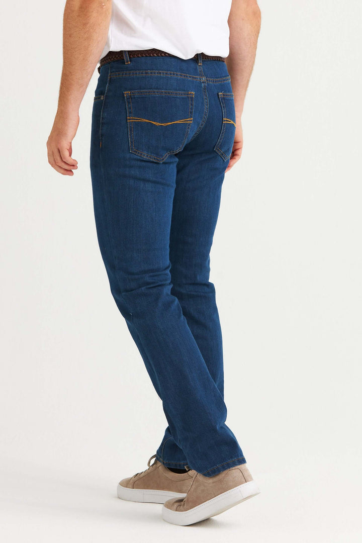 Man wearing 4500 jeans stretch mellanblå, visad från sidan, med en klassisk passform och mellanblå tvätt.
