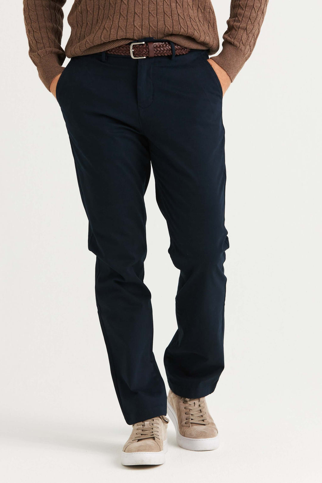 Marinblå Stretch Chinos som bärs med en brun tröja och sneakers, visande modern design och bekväm passform.