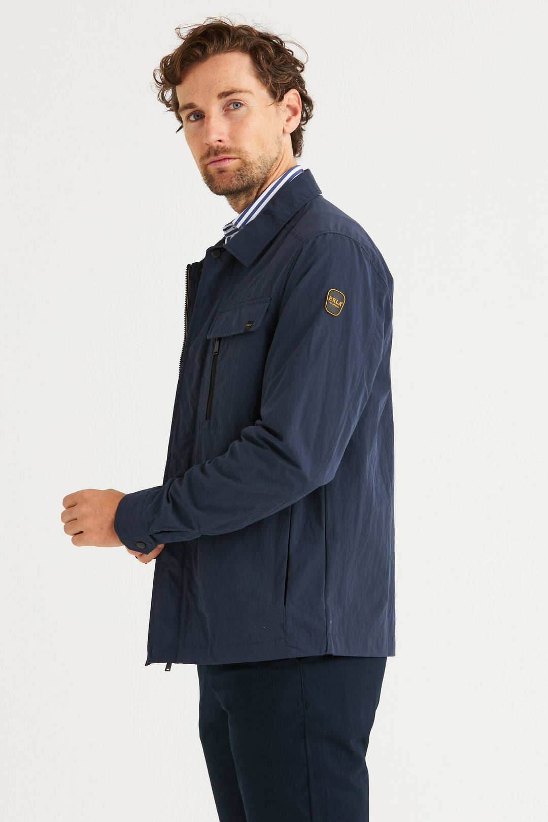 Marinblå Fieldjacka på man med stilren design och bröstfickor, perfekt för vardaglig användning.