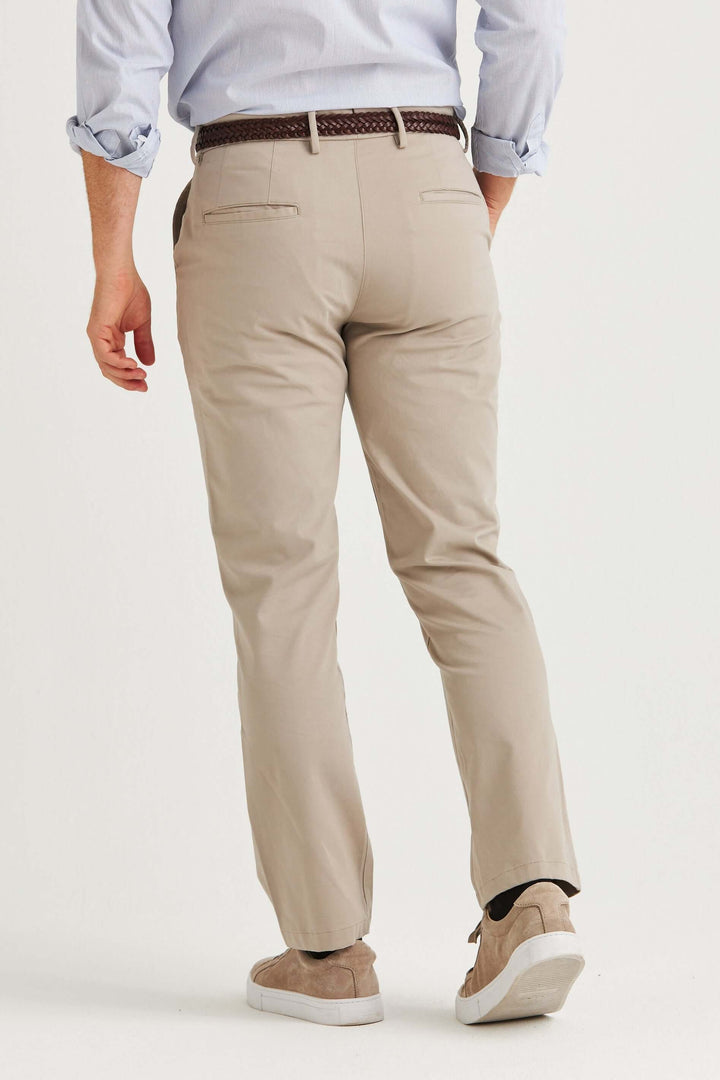 Man wearing beige stretch chinos from the back, showcasing comfort and a modern fit.