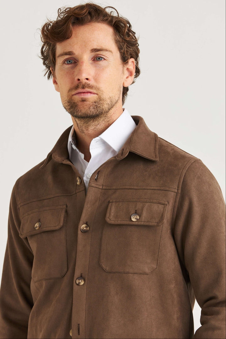 Man wearing a Brun Suede Overshirt with a modern casual style, featuring large breast pockets and a soft suede-like surface.