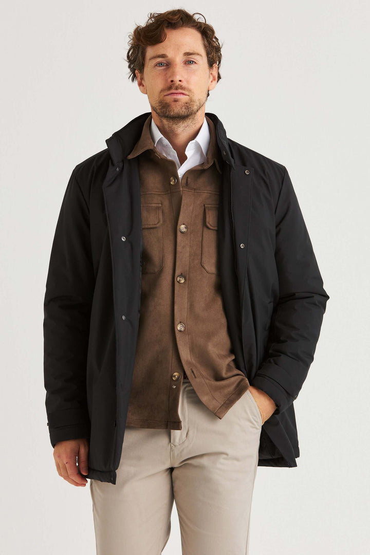 Man i svart cityjacka med en brun skjorta, elegant och modern stil.
