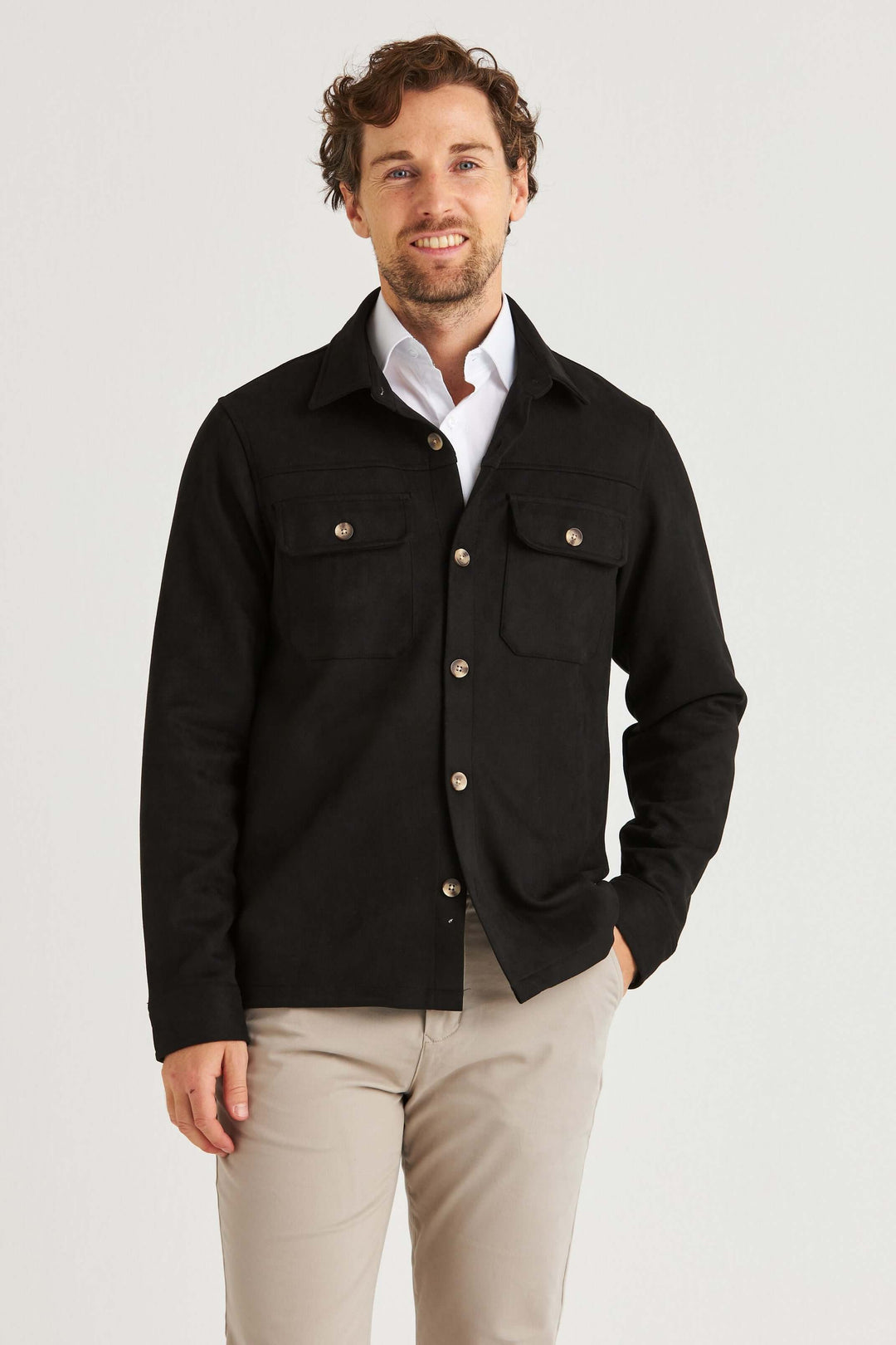 En man i svart suede overshirt med bröstfickor, kombinerad med ljusa byxor. Perfekt för en modern garderob.