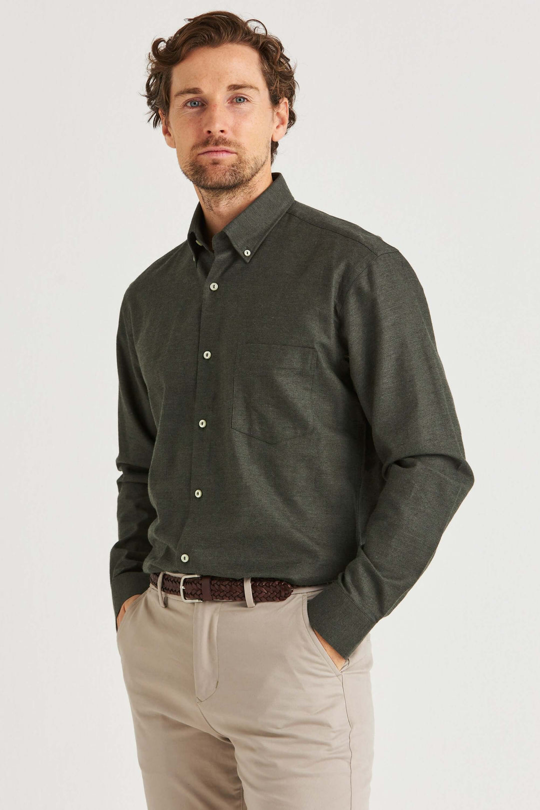 Grön Lyocellskjorta Button Down man i stilren grön skjorta med button down-krage och beige byxor.