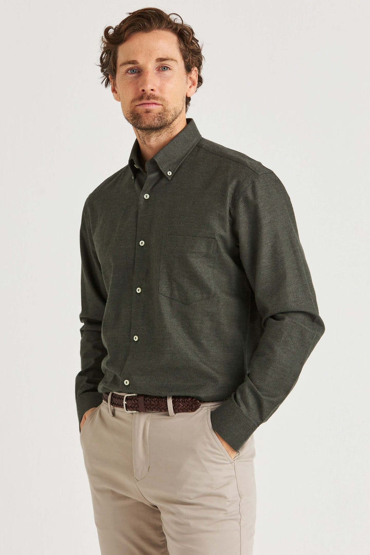 Grön Lyocellskjorta Button Down man i stilren grön skjorta med button down-krage och beige byxor.