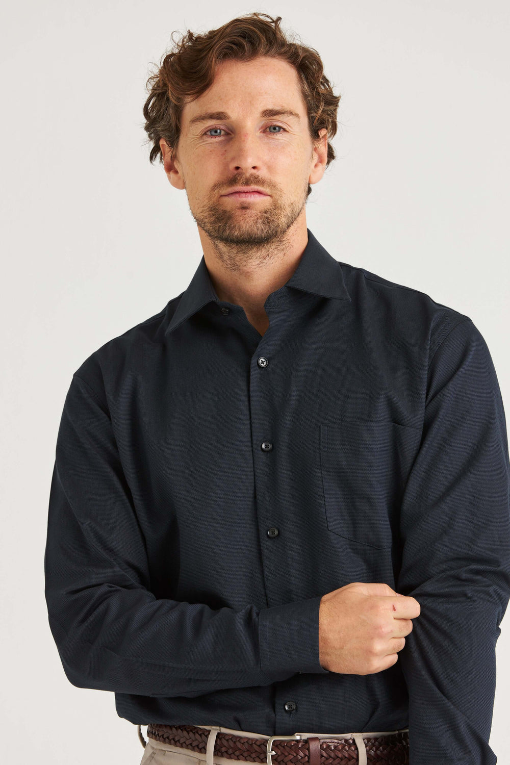 Man wearing marinblå skjorta med struktur, stilren design och vävd textur i 100% bomull.