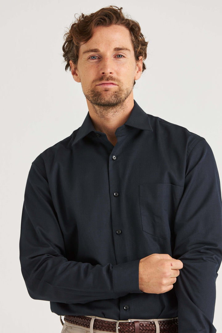 Man wearing marinblå skjorta med struktur, stilren design och vävd textur i 100% bomull.