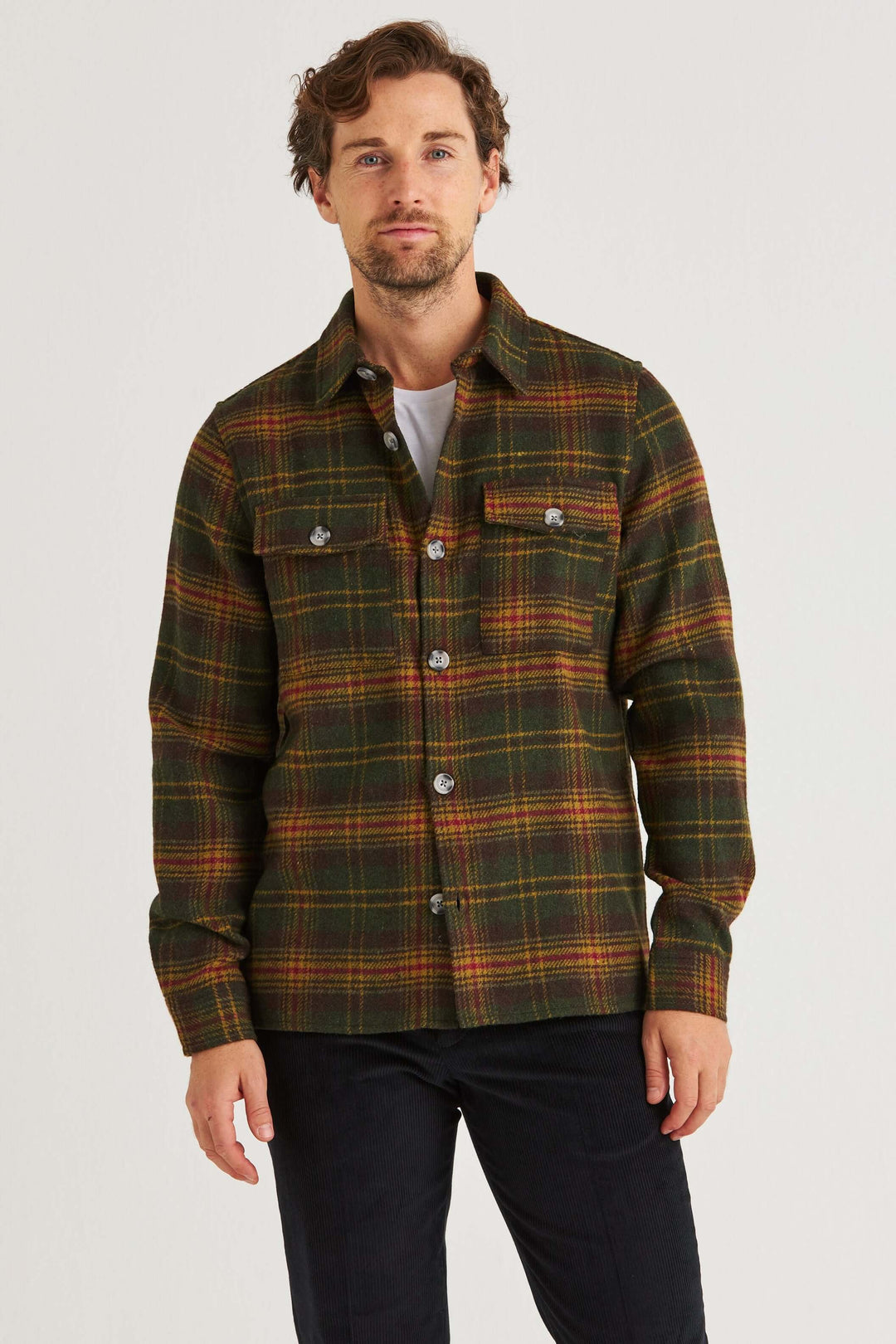 Man wearing a Grön Rutig Overshirt with a green, yellow, and red plaid pattern, perfect for autumn layering.
