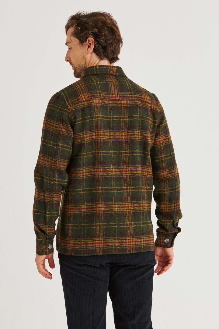 Man wearing a Grön Rutig Overshirt, showcasing its green, yellow, and red checkered pattern from the back.