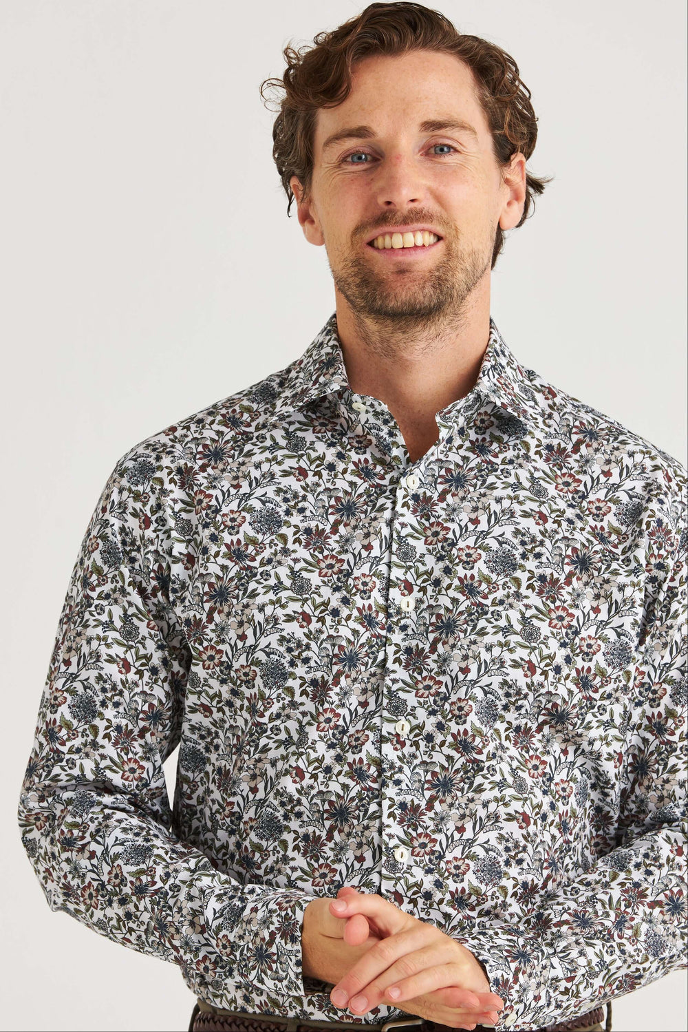 Vit Skjorta med Blommönster på en man, med ett detaljrikt blommönster i dämpade toner.