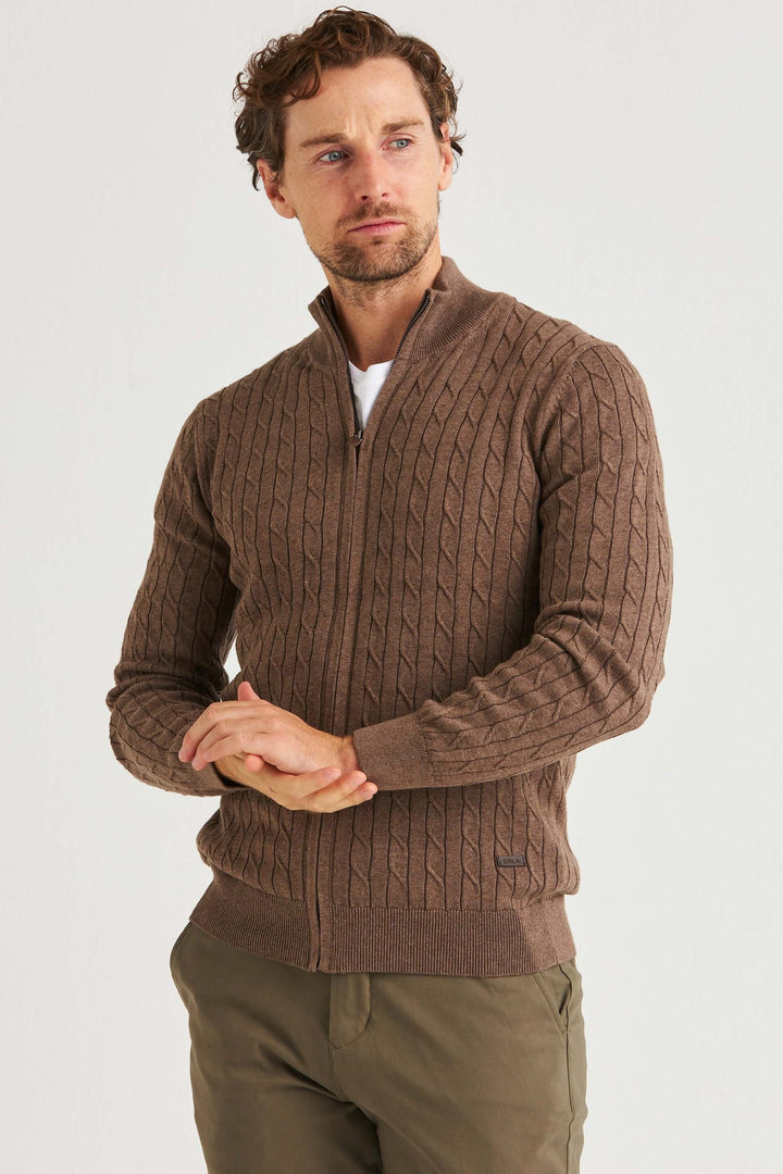 En man i brun kabelstickad full zip tröja i 100% bomull, perfekt för lager på lager styling.