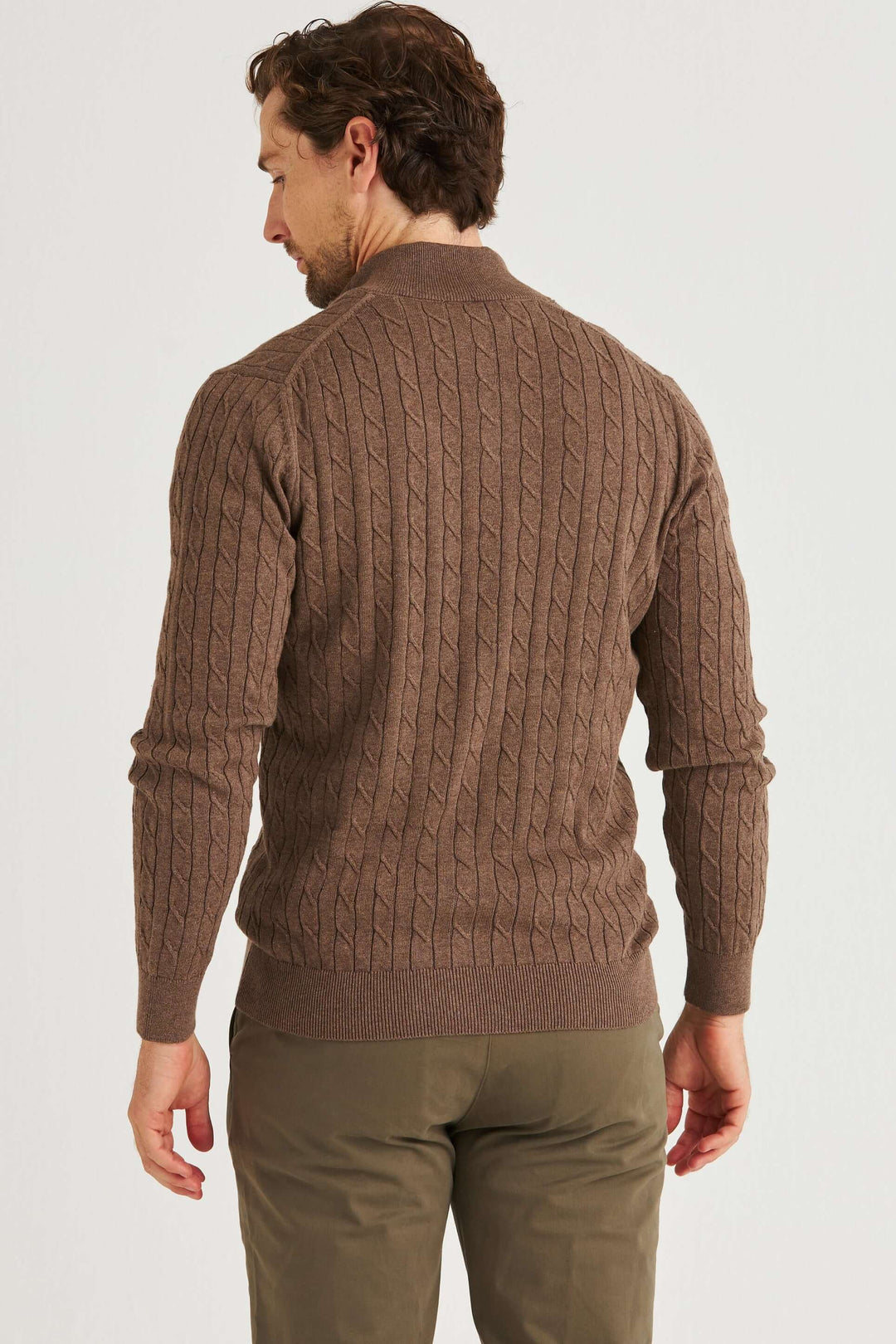 Brun Kabelstickad Full Zip i klassiskt flätmönster på manlig modell, bakifrån, med fokus på grön kabelstickad tröja.