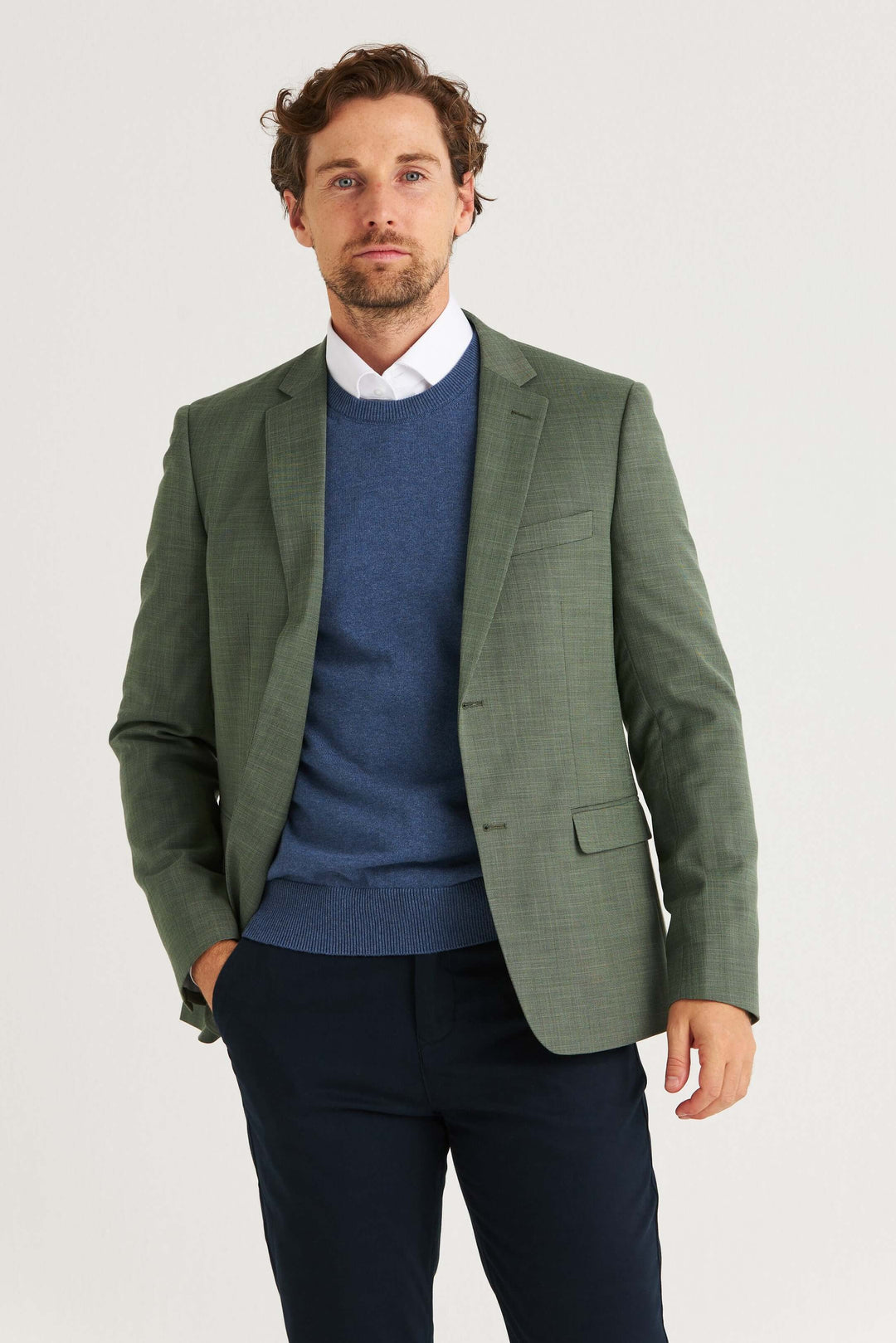 Man i grön kavaj med blå tröja och krage, perfekt för avslappnad och stilren look.