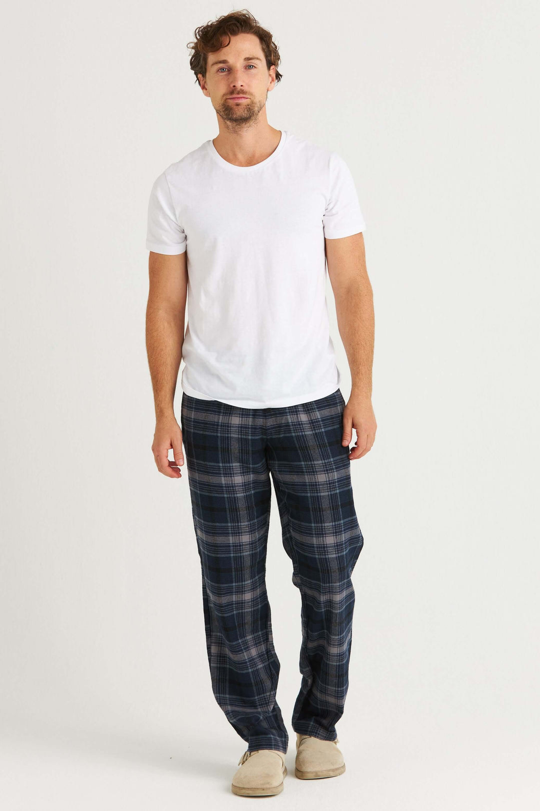 Man som bär Marinblårutig Pyjamasbyxa i Flanell, stilrena och bekväma, med klassiskt rutmönster.